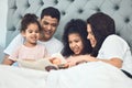 Smiling like he hit the lottery. Shot of a beautiful young family talking and bonding in bed together. Royalty Free Stock Photo
