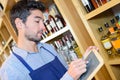 Smiling liquor store seller marking prices