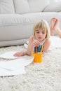 Smiling litlle girl drawing lying on the floor Royalty Free Stock Photo