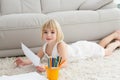 Smiling litlle girl drawing lying on the floor Royalty Free Stock Photo