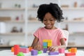 Smiling little african american girl playing with colorful wooden blocks Royalty Free Stock Photo