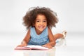 Smiling little african american girl reading book Royalty Free Stock Photo