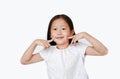Smiling little Asian child girl holding two index fingers on her cheek isolated over white background Royalty Free Stock Photo
