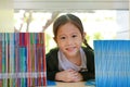 Smiling little Asian child girl lying on bookshelf at library. Children creativity and imagination concept Royalty Free Stock Photo