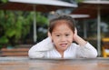 Smiling little Asian child girl lying on the wooden table with looking camera Royalty Free Stock Photo