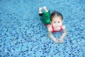 Smiling little Asian child girl in a mermaid suit playing poolside with looking camera Royalty Free Stock Photo