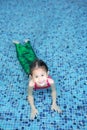 Smiling little Asian child girl in a mermaid suit playing poolside with looking camera Royalty Free Stock Photo