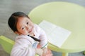 Smiling little Asian child girl sitting on kid chair and table for study in classroom Royalty Free Stock Photo