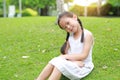 Smiling little Asian child girl with two ponytail hair lying on green grass in the garden Royalty Free Stock Photo