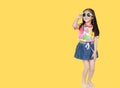 Smiling little Asian child girl wearing a floral pattern summer dress and sunglasses isolated on yellow background with copy space Royalty Free Stock Photo