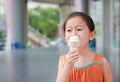 Smiling little Asian kid girl enjoy eating ice cream cone Royalty Free Stock Photo