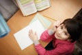 Smiling little asian schoolgirl doing homework. Royalty Free Stock Photo