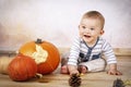 Smiling little baby sitting on the floor with pumpkins Royalty Free Stock Photo