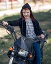 Smiling little biker riding a motorcycle Royalty Free Stock Photo