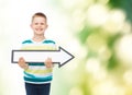 Smiling little boy with blank arrow pointing right Royalty Free Stock Photo