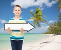 Smiling little boy with blank arrow pointing right Royalty Free Stock Photo