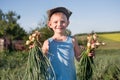 Smiling little boy with freshly harvested onions Royalty Free Stock Photo