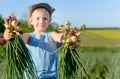 Smiling little boy with freshly harvested onions Royalty Free Stock Photo