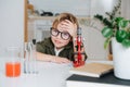 Smiling little boy in glasses sitting behind the table in front microscope Royalty Free Stock Photo