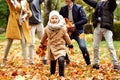 Smiling little boy Have Fun in Autumn Golden Park with family, throwing leaves and laughing. Leisure Time Spending Outdoor Royalty Free Stock Photo