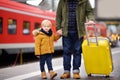 Smiling little boy and his father waiting express train on railway station platform Royalty Free Stock Photo