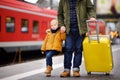 Smiling little boy and his father waiting express train on railway station platform Royalty Free Stock Photo
