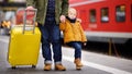 Smiling little boy and his father waiting express train on railway station platform Royalty Free Stock Photo