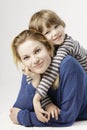 A smiling little boy and his mother hugging on the white background. Royalty Free Stock Photo