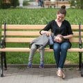 Smiling little boy lies on his mother`s hips sitting on the bench Royalty Free Stock Photo
