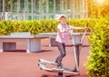 Smiling little boy on outdoor sport ground exercise at gym machine training feet and arms