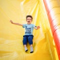 Smiling little boy playing on inflatable slide Royalty Free Stock Photo