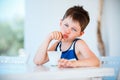 Smiling little boy refuses to eat delicious yogurt Royalty Free Stock Photo