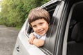 Smiling little boy rides in car, looks out the open window, have fun, enjoying auto ride, outdoors in summer Royalty Free Stock Photo