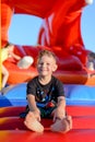 Smiling little boy sitting on a jumping castle Royalty Free Stock Photo