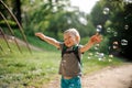 Smiling little boy with soap bubbles in summer park on sunny day Royalty Free Stock Photo