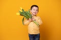 Smiling little boy on yellow studio background. Cheerful happy child with tulips flower bouquet Royalty Free Stock Photo