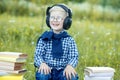 A smiling little child listens to songs in headphones. The concept of music, study, and lifestyle