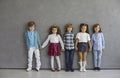 Smiling little children group stand in row against studio wall looking at camera Royalty Free Stock Photo