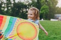 Smiling little cute child baby girl in denim dress walking, play with colorful kite and have fun in green park. Mother Royalty Free Stock Photo