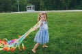 Smiling little cute child baby girl in denim dress walking, play with colorful kite and have fun in green park. Mother Royalty Free Stock Photo