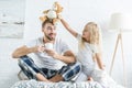 Smiling little daughter playing with teddy bear while happy father drinking tea