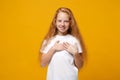 Smiling little ginger kid girl 12-13 years old in white t-shirt isolated on yellow wall background children studio Royalty Free Stock Photo