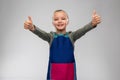 smiling little girl in apron showing thumbs up