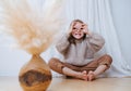 Little girl sitting in butterfly yoga position, grimasing, making finger goggles