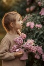 Smiling little girl with bouquet of lilac flowers Royalty Free Stock Photo