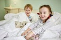 Smiling little girl and boy in bed with soft toys