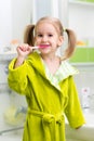 Smiling little girl brushing teeth in bath Royalty Free Stock Photo