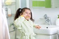 Smiling little girl brushing teeth in bath Royalty Free Stock Photo