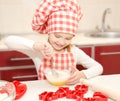 Smiling little girl with chef hat stirrring cookie dough Royalty Free Stock Photo