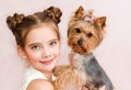 Smiling little girl child schoolgirl holding and playing with pet dog yorkshire terrier Royalty Free Stock Photo